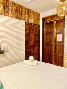 a room with a bed and a door and a room with at Xcabal Hotel boutique in Bacalar