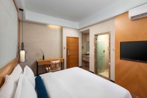 a hotel room with a bed and a flat screen tv at Days Inn by Wyndham Dali Erhai Park in Dali