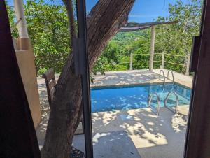 a view of a swimming pool through a glass door at Casa Arcoiris Zihuatanejo B&B in Zihuatanejo