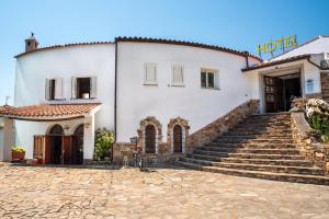 un bâtiment avec un vélo garé devant lui dans l'établissement Hotel L'Aragosta, à La Caletta