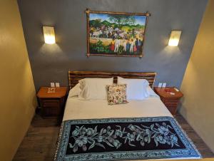 a bedroom with a bed with a painting on the wall at Casa Arcoiris Zihuatanejo B&B in Zihuatanejo +37 photos