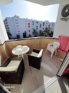 - Balcón con mesa y sillas en un edificio en Holiday Apartment, en Playa del Inglés