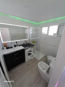 Baño blanco con aseo y lavamanos en Holiday Apartment, en Playa del Inglés