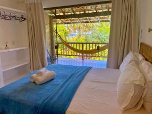 a bed with a towel laying on top of it at Sup House Barra Grande in Barra Grande