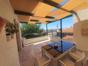 a dining room with a table and a balcony with a view at st945 Palas Otel in İzmir