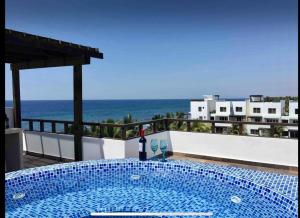 una piscina con una botella de vino junto al océano en PENTHOUSE EN MONTERRICO en El Sunzo