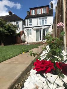 una casa con una cama de flores en el patio delantero en Family and Private Home en Norbury