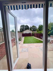a patio door with a view of a yard at Family and Private Home in Norbury