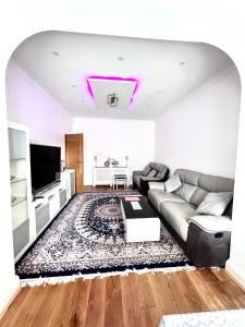 a living room with a couch and a tv at Family and Private Home in Norbury