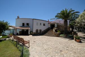 un grand bâtiment blanc avec des escaliers et un palmier dans l'établissement Hotel L'Aragosta, à La Caletta