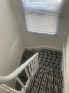 a staircase in a room with a window at Spacious loft space with private en-suite bathroom in London