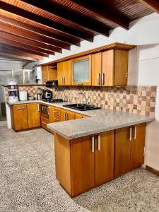 uma cozinha com armários de madeira e bancadas de granito em Sereni Laureles Hotel Cafe em Medellín