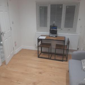 - un salon avec une table et un ordinateur portable dans l'établissement Spacious loft space with private en-suite bathroom, à Londres