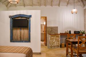 Pokój z łóżkiem i telewizorem na ścianie w obiekcie Riviera Trancoso w mieście Trancoso