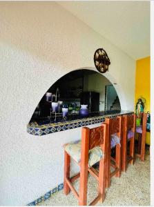 a kitchen with a counter with a table and chairs at Hermosa casa privada con alberca. in Veracruz