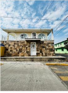 a brick house with a white door on a street at Hermosa casa privada con alberca. in Veracruz