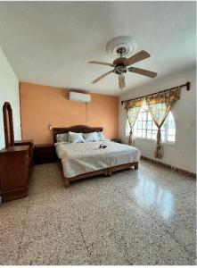 a bedroom with a bed and a ceiling fan at Hermosa casa privada con alberca. in Veracruz