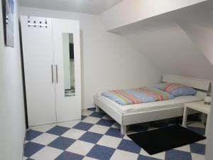 Dormitorio pequeño con cama y espejo en Ruhige gemütliche Ferienwohnung in Karlsruhe Daxlanden für Monteure, Pendler, Geschäfsreisen, Wochenendreisen, en Karlsruhe