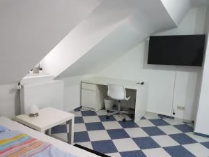 1 dormitorio con escritorio y 1 cama con monitor en Ruhige gemütliche Ferienwohnung in Karlsruhe Daxlanden für Monteure, Pendler, Geschäfsreisen, Wochenendreisen, en Karlsruhe