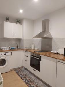 a kitchen with white cabinets and a stove top oven at Apartamento Silleda Confort in Silleda