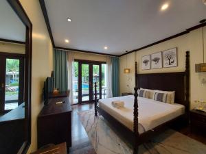 ein Schlafzimmer mit einem Bett und einem TV in der Unterkunft Sunrise Garden House - Luang Prabang in Luang Prabang