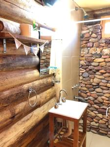 uma casa de banho com um lavatório e uma parede de pedra em cabañas de montaña em Uspallata