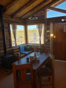 einen Holztisch und Stühle in einem Zimmer mit Fenster in der Unterkunft cabañas de montaña in Uspallata