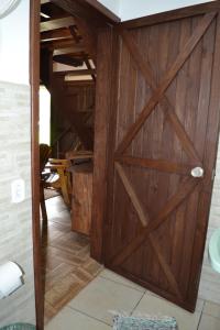 a wooden garage door in a bathroom with a tile floor at Hostel e Camping Vale Mirante da Rocha in Timbe do Sul +76 photos