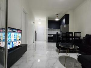 a living room with a flat screen tv and a couch at Black'n White Apartment in Vlorë