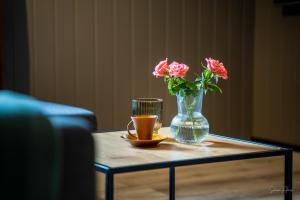 una mesa con un jarrón y una taza de café y flores en Alpan Apartments, Lyngenfjord, en Olderdalen