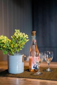 una botella de cerveza y dos copas de vino en una mesa en Alpan Apartments, Lyngenfjord, en Olderdalen