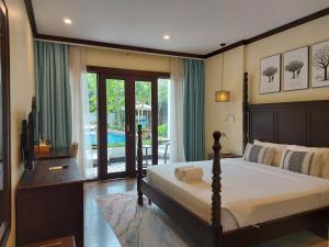 a bedroom with a bed and a television in it at Sunrise Garden House - Luang Prabang in Luang Prabang
