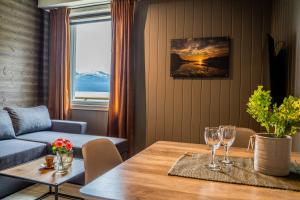 una sala de estar con una mesa con copas de vino. en Alpan Apartments, Lyngenfjord, en Olderdalen