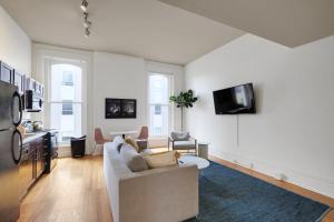 a living room with a couch and a tv on a wall at Historic Charm, Walkable Entertainment in Louisville