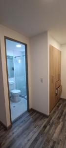 een lege badkamer met een toilet en een glazen deur bij 86 suites in Bogota