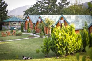 a log cabin with a garden and a picnic shelter at Tara Riverside in Mojkovac