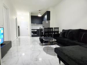 a living room with a couch and a table at Black'n White Apartment in Vlorë