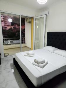 a bedroom with a large bed with towels on it at Black'n White Apartment in Vlorë +20 photos