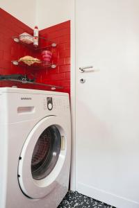 - un lave-linge dans une pièce dotée d'un mur rouge dans l'établissement While apartment underground and bus station a/c, à Milan