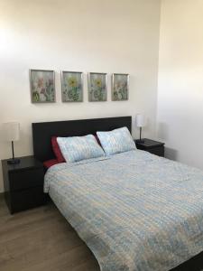 sypialnia z łóżkiem i trzy obrazy na ścianie w obiekcie 310Guest-House La Vyda w mieście San Juan
