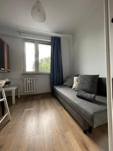a living room with a couch and a window at Rooms4Less in Gdańsk