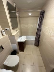 a small bathroom with a toilet and a sink at Rooms4Less in Gdańsk
