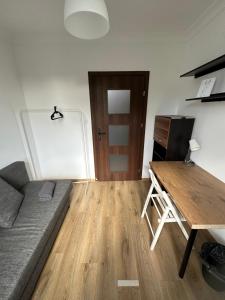 a living room with a couch and a wooden table at Rooms4Less in Gdańsk +14 photos