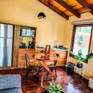 sala de estar con mesa de madera y cocina en Cabañas Las Morenas Mazamitla, en Mazamitla