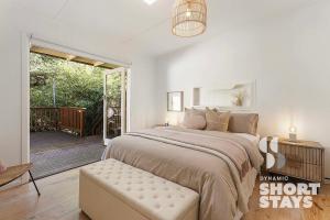 - une chambre avec un grand lit et une terrasse couverte dans l'établissement Discover Elegance at Silvermist, à Kallista
