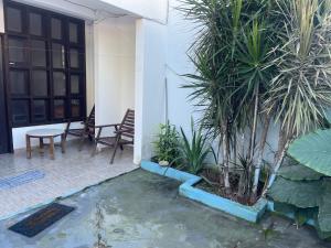a courtyard with a table and chairs and palm trees at Condomínio Canto das Orquídeas VI in Porto Seguro