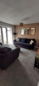 a living room with two couches and a mirror at Modern Town House in Mid Wales in Knighton