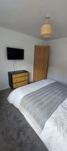 a bedroom with a white bed and a television at Modern Town House in Mid Wales in Knighton
