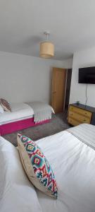 a hotel room with two beds with a pillow on it at Modern Town House in Mid Wales in Knighton