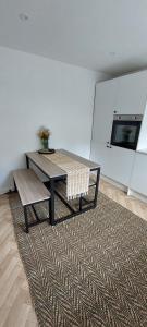 a room with a table and a bench on a rug at Modern Town House in Mid Wales in Knighton